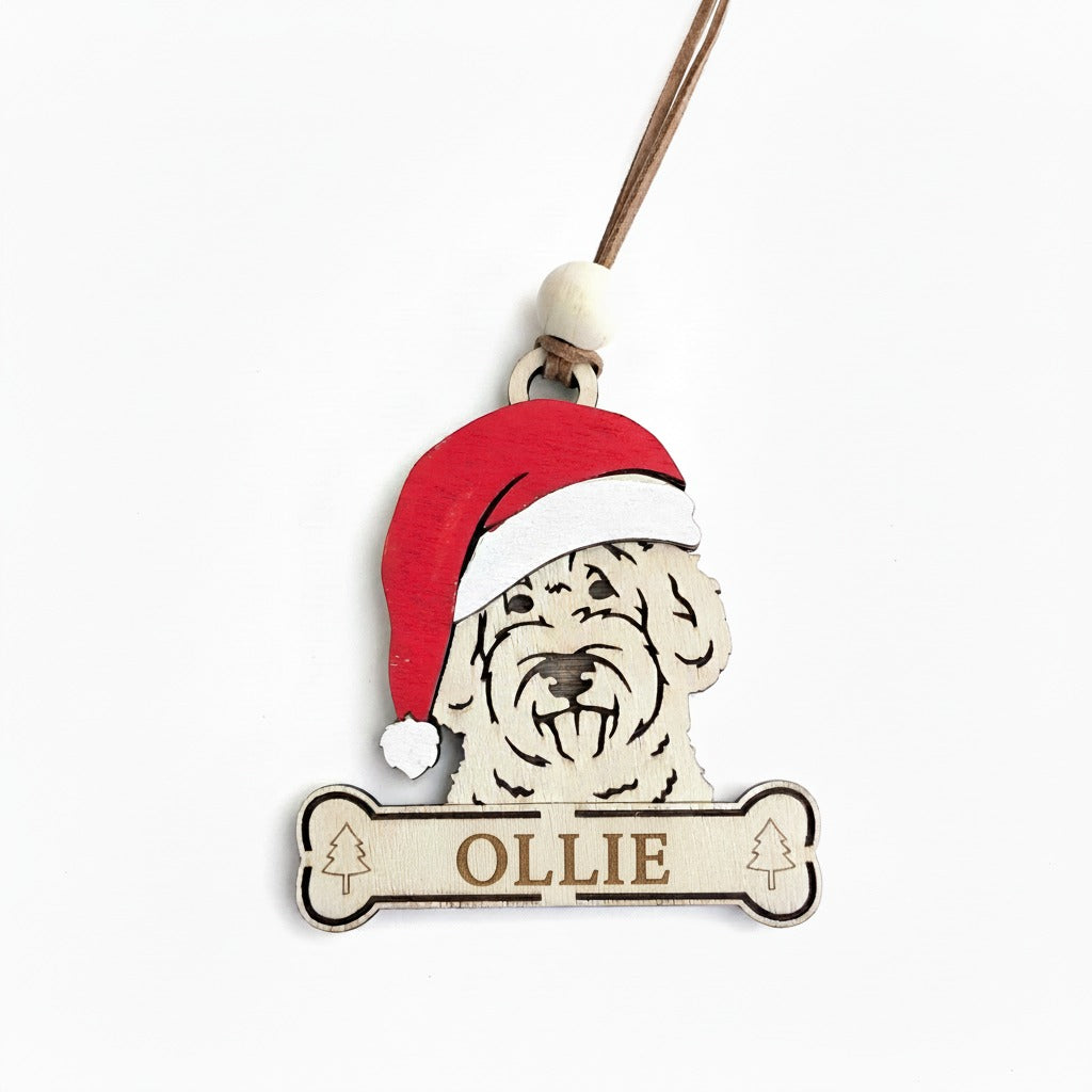 Christmas tree ornament of a dog's face wearing a Santa hat